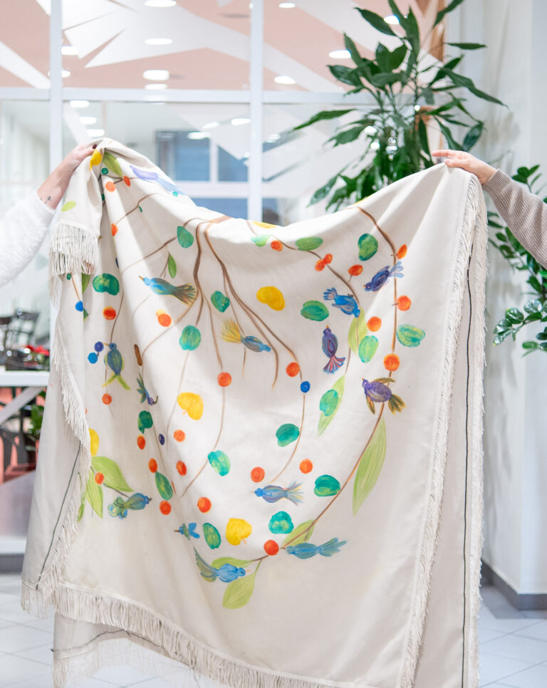 Das Sargtuch in der CS Caritas Socialis in der Pramergasse liegt in einer Kiste in einem Schrank bei der Rezeption bereit. Die (ehemaligen) Hospiz-Bewohner*innen haben es selbst bemalt. © Sanna Hätönen